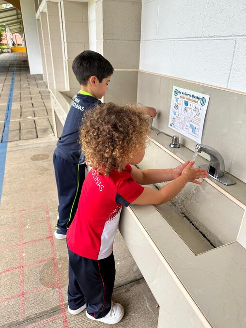 Niños lavándose las manos para la prevención de enfermedades en APDE Las Colinas